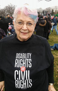 Sally Weiss smiling at the camera wearing a shirt the text disability rights are civil rights