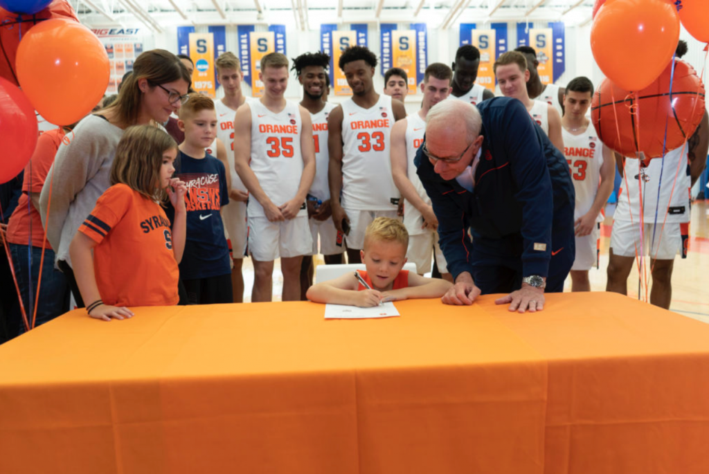Team IMPACT and Coach Boeheim sign Mason, a 6 year old with Spina Bifida as an official (non-playing) member of the Syracuse University Men’s Basketball athletic team. 